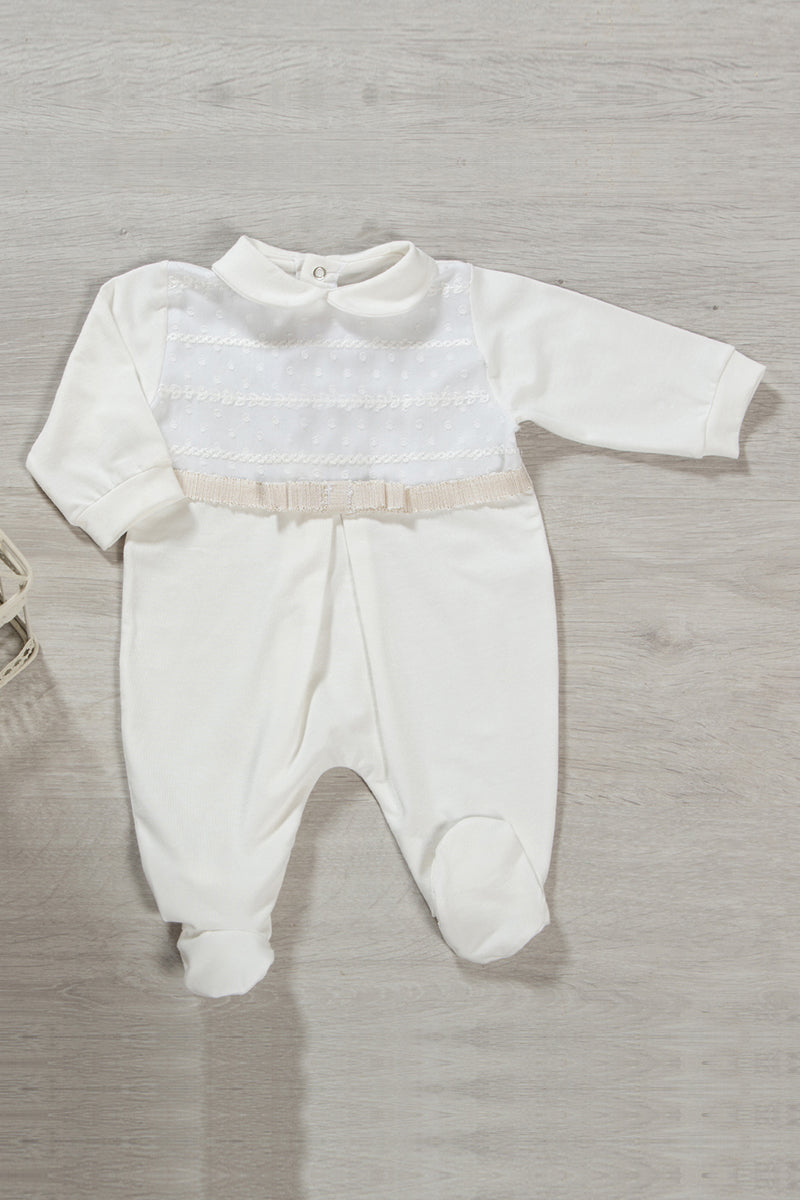 Tutina in cotone elasticizzato con inserto in tessuto ricamato in rilievo, nastro in gros grain con fili in oro, fiocco e piega centrale