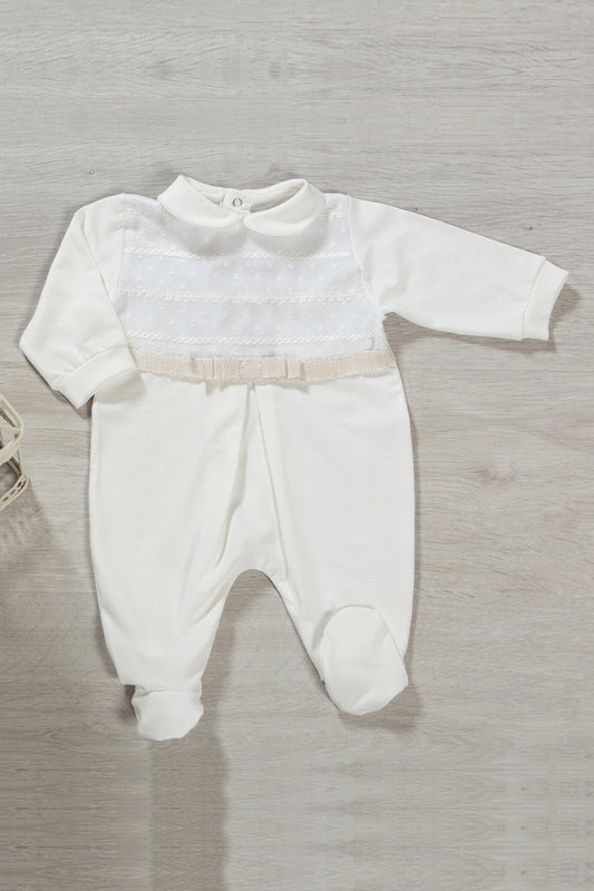 Tutina in cotone elasticizzato con inserto in tessuto ricamato in rilievo, nastro in gros grain con fili in oro, fiocco e piega centrale