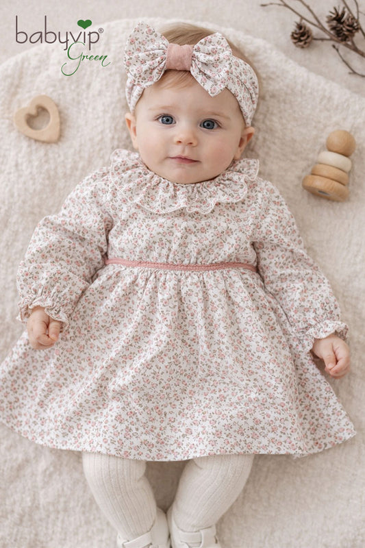 Vestitino in cotone organico fantasia floreale con balza allo scollo, maniche a sbuffo, taglio con rouches e nastrino in velluto in contrasto